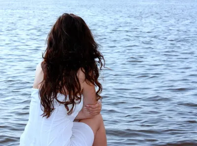 Фото девушки со спины, которая сидит в воде и смотрит на закат — Фото  аватарки